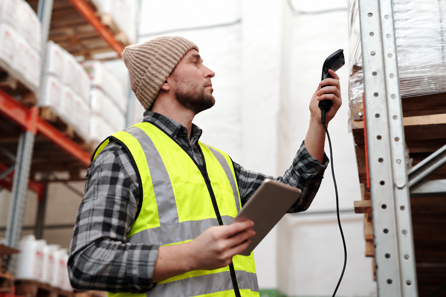 Profissional conferindo ativos com coletor e tablet em um warehouse